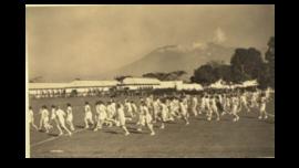 PARADE SISWA H.B.S. DALAM MENU OLAHRAGA SELAMA HARI OLAHRAGA DI MALANG, JAWA. DI LATAR BELAKANG SEBUAH GUNUNG BERAPI